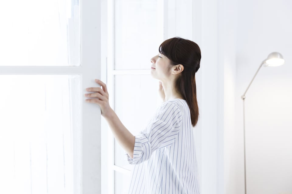 内開き窓を開けている女性