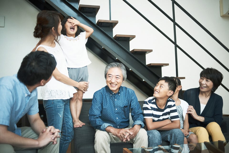力桁階段があるリビングで団らんする家族